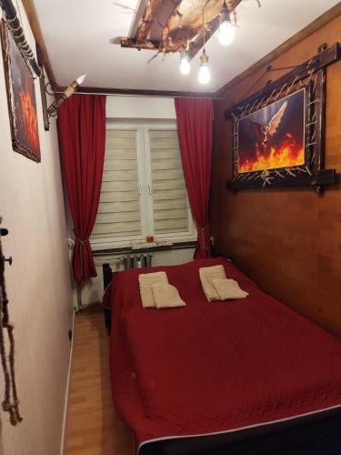 a bedroom with a red bed with two towels on it at Mroczne marzenie in Przemyśl