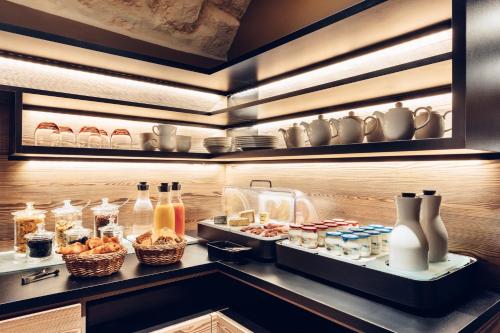 パリにあるHôtel de Lille - Saint-Germain des Prèsのキッチン(棚の上に食べ物や飲み物を用意)