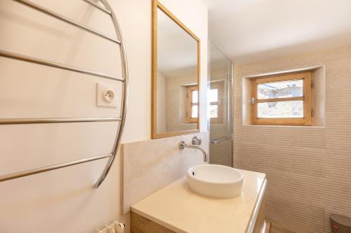 un bagno con lavandino e specchio di Cal Bénétou - Belle Maison pour 12, vue montagne a Les Angles