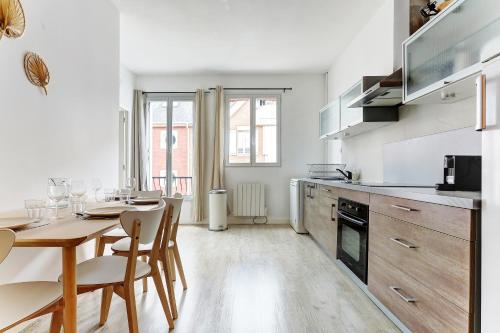 une cuisine avec une table et des chaises dans une pièce dans l'établissement Le Bubbly - Appartement lumineux de 50m², à Épernay