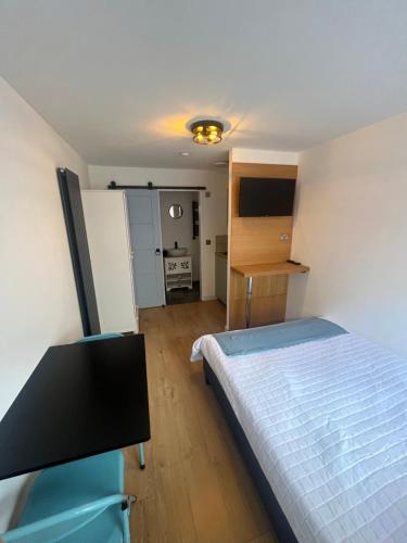 a small bedroom with a bed and a kitchen at Teddington Little Gem in London