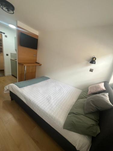 a bedroom with a bed with a light on the wall at Teddington Little Gem in London