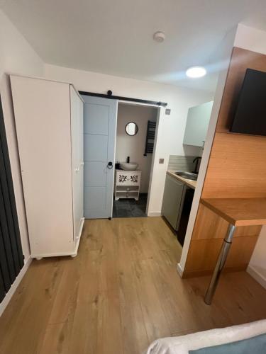 a room with a door and a table and a kitchen at Teddington Little Gem in London