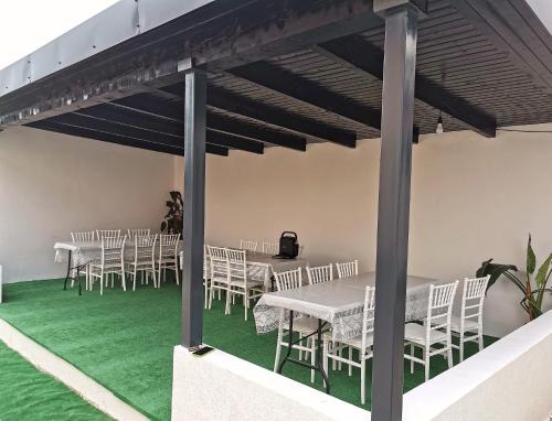 a group of tables and chairs on a green floor at Pensiunea Fira in Baia de Fier