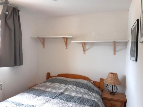 - une chambre avec un lit et des étagères sur le mur dans l'établissement Appartement 2 pièces, 6 pers, proche pistes, animaux OK - FR-1-561-29, à Valfréjus