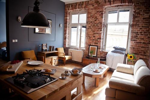 uma sala de estar com um sofá e uma mesa em Loft Apartment Industrial Design em Cracóvia