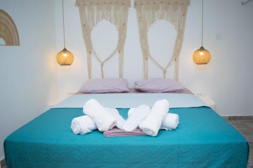 un lit bleu avec deux serviettes blanches dessus dans l'établissement Endless Blue from Syros - Megas Gialos Suite 2, à Liaropá