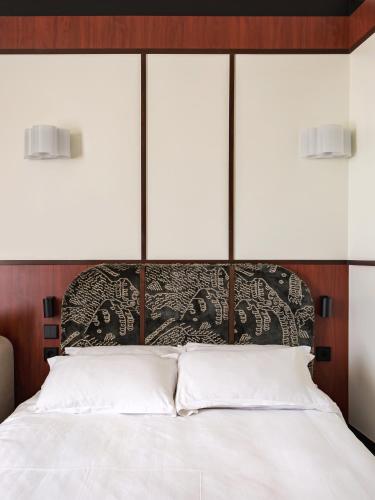 a bed with a black and white head board at Hôtel Marguerite in Paris