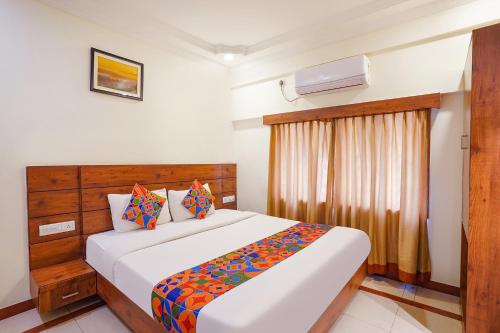 a bedroom with a large white bed and a window at FabHotel Savi Inn - Nr Mantri Square Mall in Bengaluru