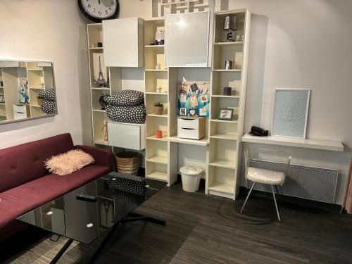 - un salon avec un canapé rouge et des étagères dans l'établissement Place de la Bastille, à Paris