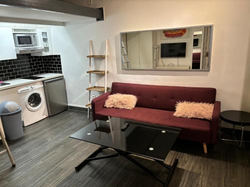 un salon avec un canapé rouge et un miroir dans l'établissement Place de la Bastille, à Paris