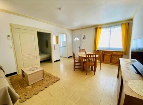 un salon avec une table, des chaises et une télévision dans l'établissement Les pieds dans le sable, au Grau-du-Roi