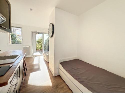 une chambre avec un lit dans le coin d'une pièce dans l'établissement Studio meublé Frejus Lagon Bleu, à Fréjus