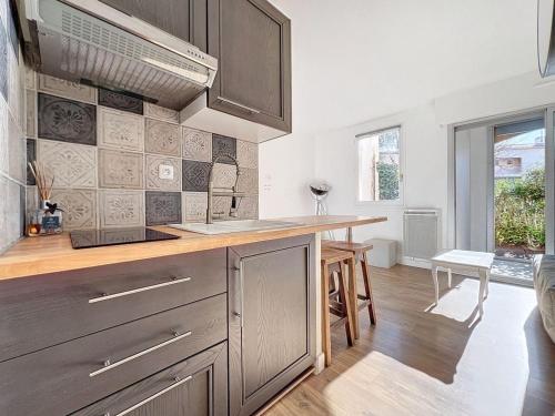 une cuisine avec des armoires en bois et un comptoir dans l'établissement Studio meublé Frejus Lagon Bleu, à Fréjus