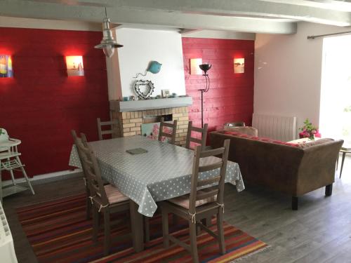 d'une salle à manger avec une table, des chaises et des murs rouges. dans l'établissement Maison typique de pêcheur, à Noirmoutier-en-l'lle