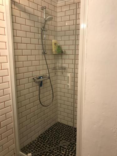 a shower in a bathroom with white tiles at Maison typique de pêcheur in Noirmoutier-en-l'lle