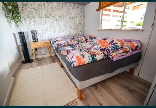 a small bedroom with a bed and a table at Domek na Roztoczu - Jacuzzi in Krasnobród
