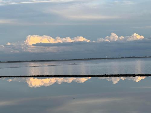 a large body of water with clouds in the sky at Ferienwohnung Capitano in Eckwarden