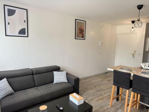 una sala de estar con un sofá y una mesa en Luxurious and Stylish Studio Between Disney & Paris, en Champs-Sur-Marne