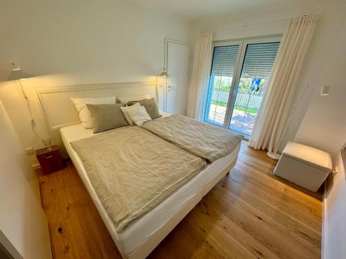 a bedroom with a large bed and a window at Ferienwohnung Capitano in Eckwarden