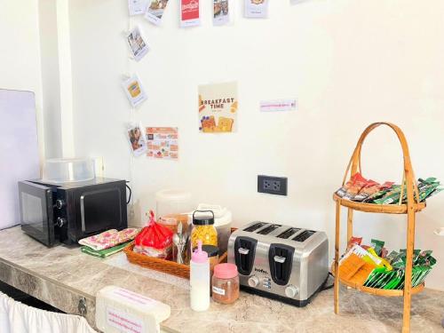 a kitchen counter with a toaster and a microwave at Baan Kun Mhor Hostel บ้านคุณหมอโฮสเทล in Bangkok