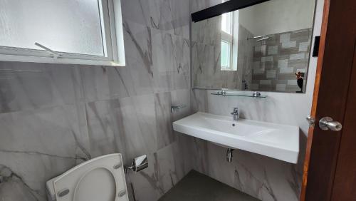 a bathroom with a sink and a toilet and a mirror at The Cloud Hanthana, Kandy in Kandy
