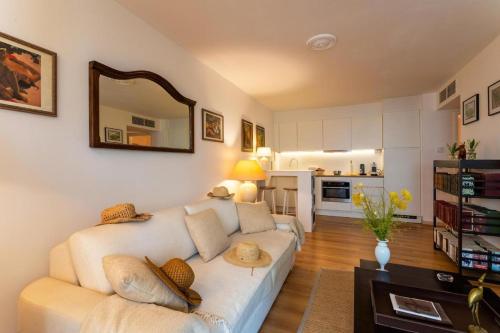 un salon avec un canapé blanc et une cuisine dans l'établissement NICE SuiteMarie Carre d'or, à Nice