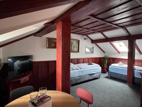 a room with two beds and a table and a tv at Penzión Grand, Self Check-In, free private parking in Banská Bystrica
