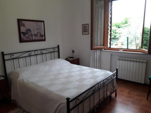 a bedroom with a bed and two windows at Casa Aralia con giardino in Chianciano Terme