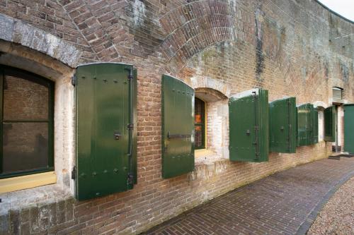 a row of green doors on the side of a brick building at Fort Vuren in Vuren