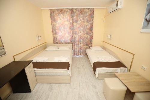 a small room with two beds in it at Family Hotel White House in Pomorie
