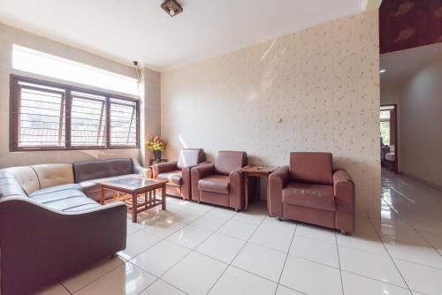 a waiting room with couches and chairs and a table at Urbanview Hotel Sakura Bandung in Bandung