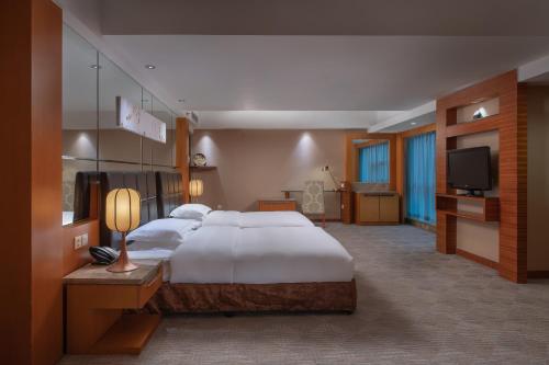 a large bedroom with a large bed and a television at Empark Grand Hotel Xi'an in Xi'an