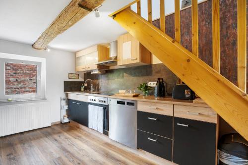 a kitchen with wooden cabinets and a staircase at Wünsch Dir was in Großweitzschen