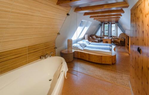a bathroom with a bath tub and a bedroom at Penzion Ovečka in Nýdek