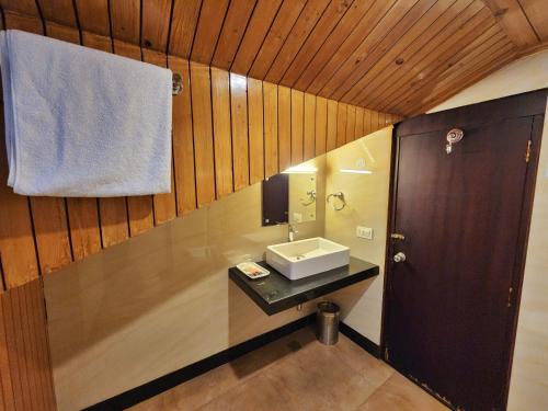 a bathroom with a sink and a towel at Hotel Surya Shimla in Shimla