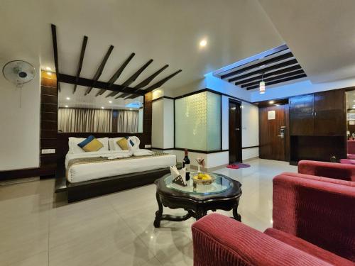 a bedroom with a bed and a table in a room at Hotel Surya Shimla in Shimla
