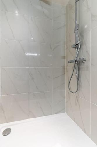 une douche avec pommeau de douche dans une salle de bain dans l'établissement Montparnasse Rue de Rennes Charming apartment 2P, à Paris