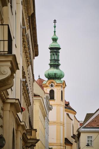 a building with a tower with a clock on it at Hotel Deutschmeister in Vienna
