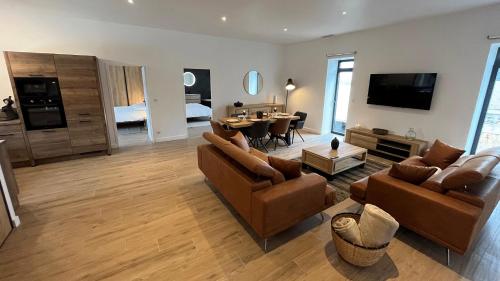un salon avec un canapé et une salle à manger dans l'établissement Gîte Berlou Moderne & Authentique, à Berlou