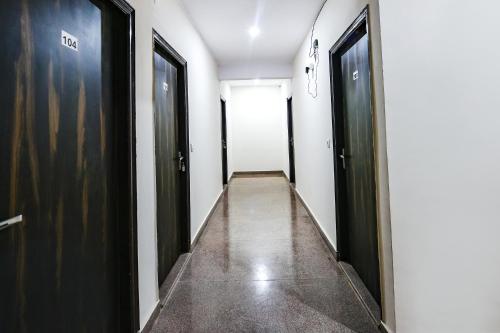 a hallway with two black doors at FabHotel The Yashobhumi Near Yashobhoomi Convention Centre in New Delhi