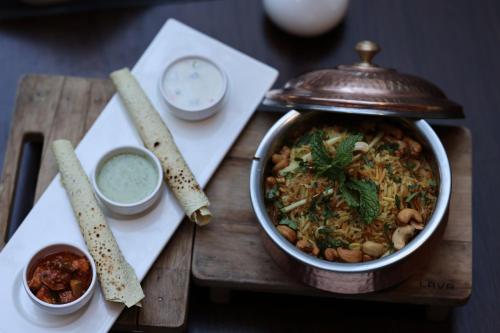 a table with a pot of food on a wooden tray at Ramada by Wyndham Dubai Barsha Heights in Dubai