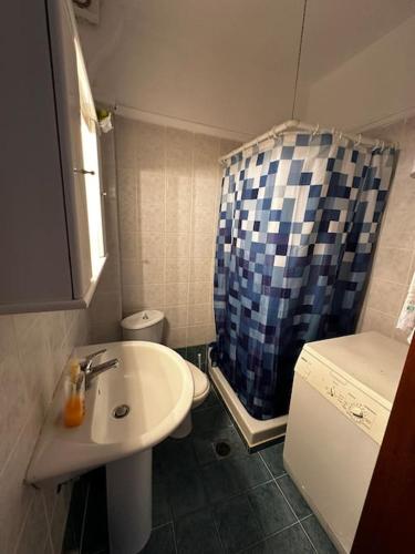 a bathroom with a sink and a toilet and a shower at House 77 in Kallithea Halkidikis