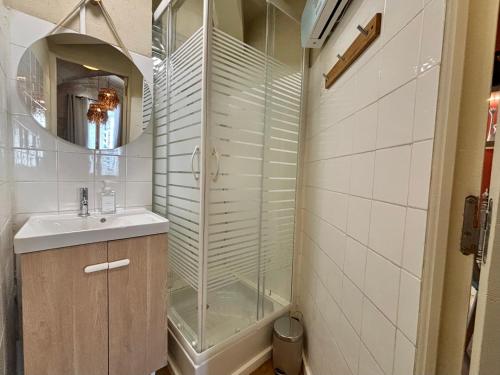 a bathroom with a glass shower and a sink at Joli appartement voûté dans le centre ville in Avignon