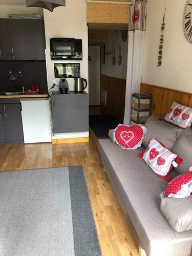 un salon avec un canapé et une cuisine dans l'établissement L'étoile des neiges Studio confort pour 4 personnes, à Montclar