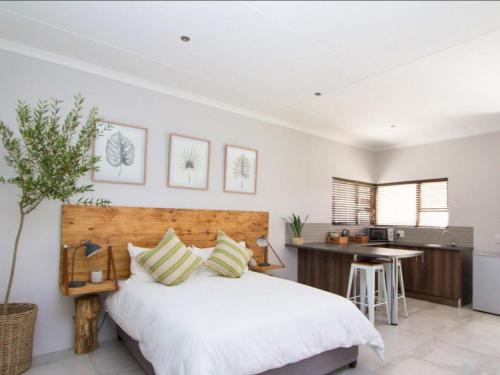 a bedroom with a large bed and a kitchen at Maxton Boutique Hotel Upington in Upington