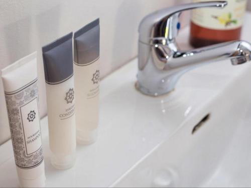 three tubes of sunscreen sitting on a bathroom sink at Maxton Boutique Hotel Upington in Upington