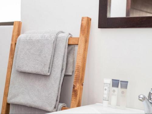 a towel rack with towels on it in a bathroom at Maxton Boutique Hotel Upington in Upington