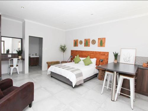 a bedroom with a bed and a desk and a couch at Maxton Boutique Hotel Upington in Upington