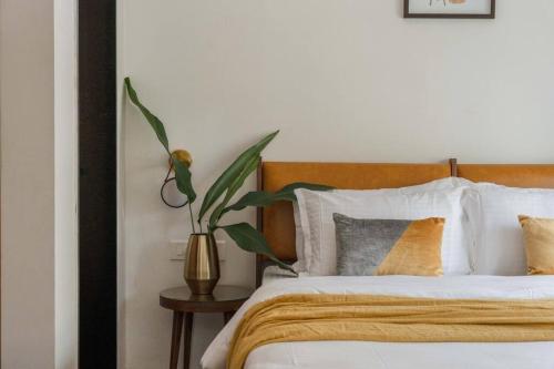 a bedroom with a bed with a plant on a table at Nistula Luxury Villa with Private Pool in Assagao in Assagao